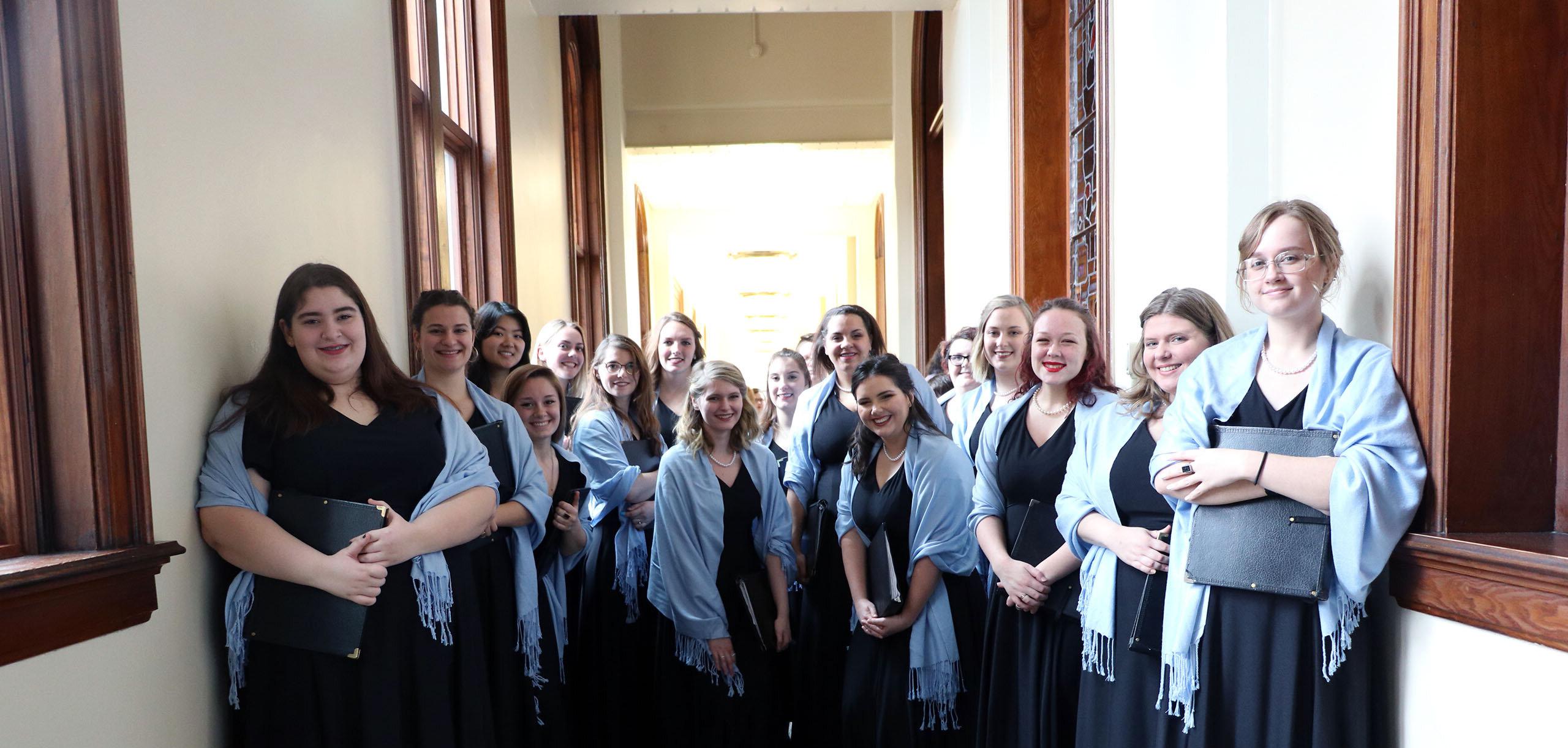 Choir students smile for a group picture before a concert